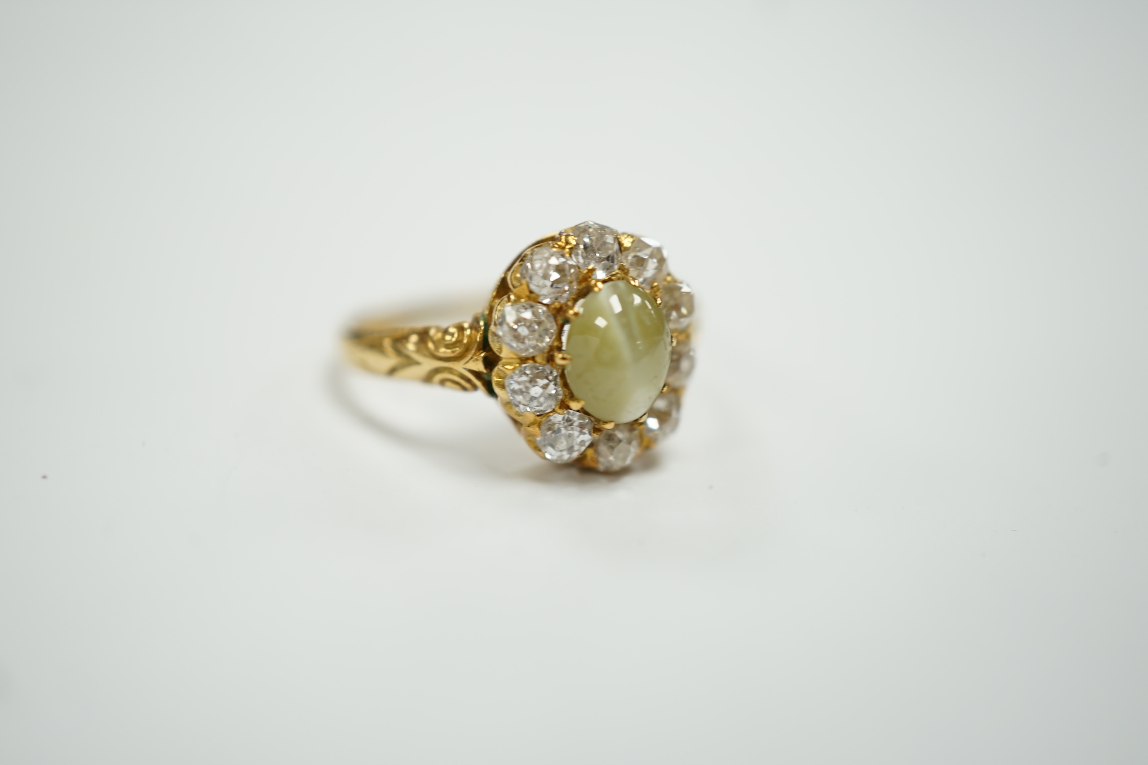 A yellow metal, cat's eye chrysoberyl and diamond cluster set ring, size L, gross weight 2.9 grams.